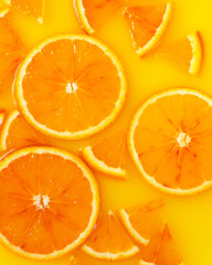 Top view of red orange slices in juice as background