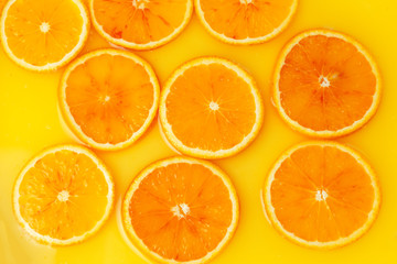 Top view of red orange slices in juice as background