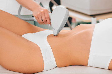 Woman having laser epilation, hair removal on belly