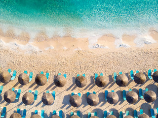 Fototapeta na wymiar Greek beach with sunbeds and umbrellas top down aerial view