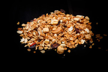 big scattered heap of granola with assorted nuts and dried cacao