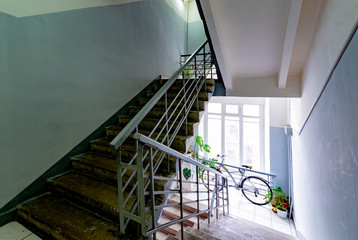 Staircase with forged railings on the railing in the old stairwell
