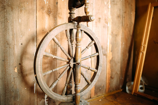 vintage wooden spinning wheel for yarn on a rustic boardwalk background