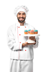 Male confectioner with tasty dessert on white background