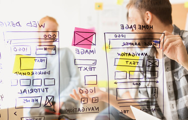 IT designers discussing project, view through transparent board