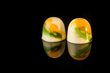 two sphere shaped white chocolate candies with colorful decoration
