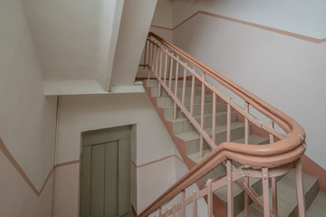 Staircase with forged railings on the railing in the old stairwell