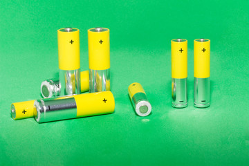 AA batteries on green background. Concept of recycling