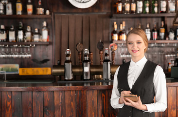 Young female waiter in bar