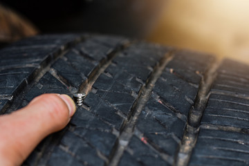 Close up tack in tire ,Flat tire The tire is leaking from the nail Can a Tire be Repaired © jes2uphoto