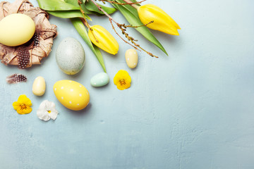 Osternest und Ostereier mit Tulpen auf Hintergrund in blau, Osterkarte
