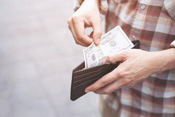 Businessman Person holding an wallet in the hands of an man take money out of pocket.