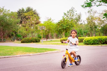 Little girl riding balance bike in the park