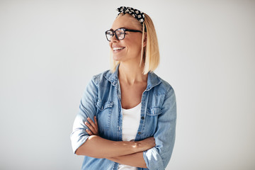 Laughing young female entrepreneur wearing glasses against a whi