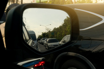 Evening road traffic convey stories from the car side mirror