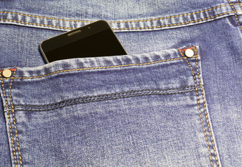 Black smartphone in the back pocket of blue jeans.
