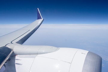 wing of plane in high blue sky view through window aircraft