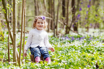 Cute teenager girl on Easter egg hunt in blooming spring garden. Children in snow drop flower meadow. Springtime in the garden