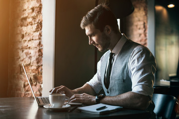 Young businessman working on a plan of Internet project on the laptop. Man discusses business matters by phone. Working computer for internet research. Digital marketing. Development