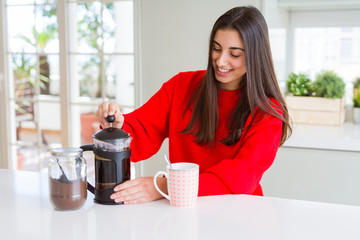 Young beautiful woman making morning coffee smiling, preparing a cup of latte for breakfast