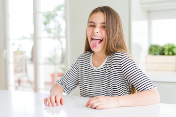 Beautiful young girl kid wearing stripes t-shirt sticking tongue out happy with funny expression. Emotion concept. © Krakenimages.com