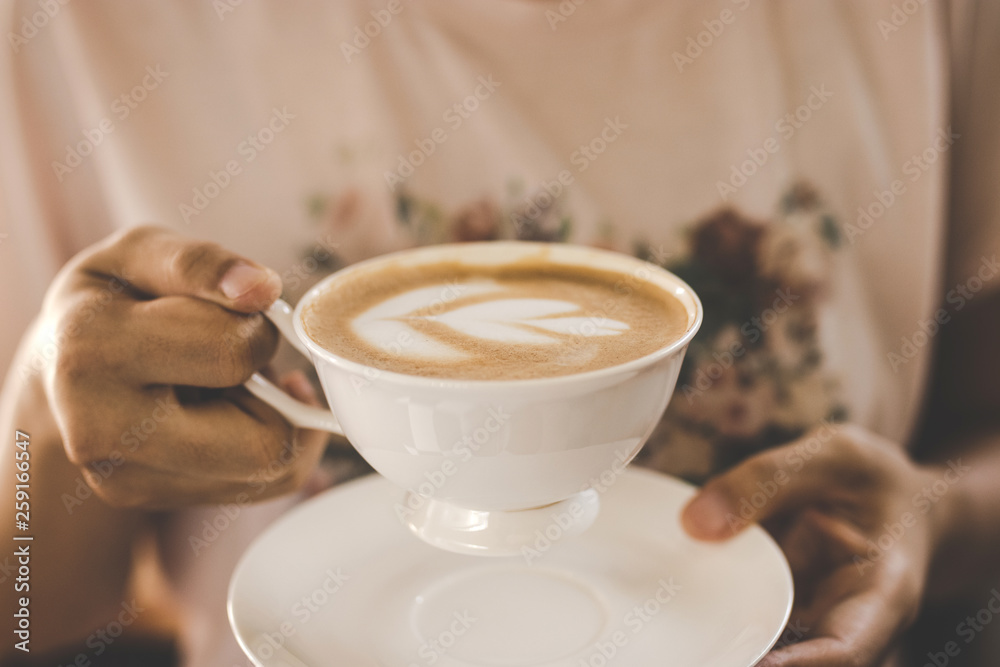 Wall mural female hands holding coffee latte art