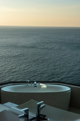 Obraz premium View from a bath room in a luxury hotel, seeing bathtub with a faucet set superimposed or double exposure with a beautiful sea view of Pattaya and islands around. 