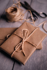 Fototapeta na wymiar Gift packages of kraft paper, rope and scissors