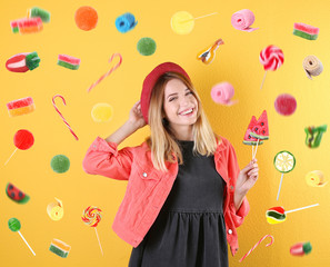 Young pretty woman with candies on colorful background