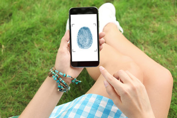Woman holding smartphone with blank screen outdoors. Mockup for design