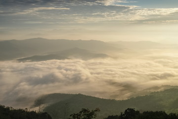 Mountain view morning of the hills around with sea of mist and soft yellow sun light in the sky background, sunrise at Doi Samur Dao, Sri Nan National Park, Nan, Thailand.