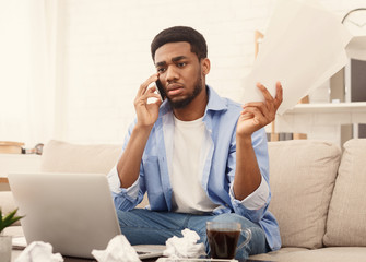 Serious man holding paper and talking on mobile phone