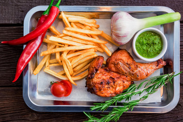 Top view meal with chicken thigh, french fries, chili pepper and garlic