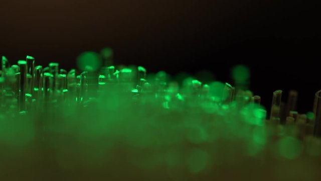 Macro footage of optical fibers switching collors on black backgorund for creating a abstract background 