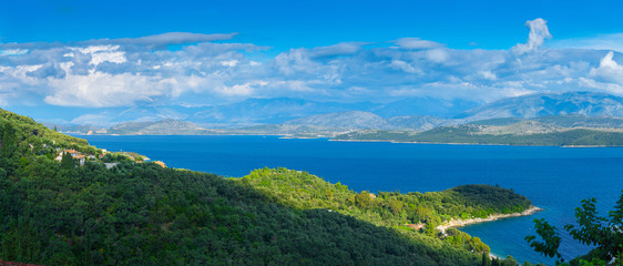 Obraz premium Beautiful summer panoramic seascape. Green slopes in close bays with crystal clear azure water. Coastline of north part Corfu island, Ionian archipelago, Greece.