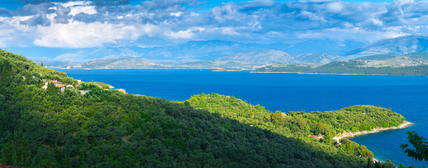 Fototapeta na wymiar Beautiful summer panoramic seascape. Green slopes in close bays with crystal clear azure water. Coastline of north part Corfu island, Ionian archipelago, Greece.