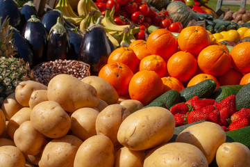 Beautiful composition of various fresh and ripe biological vegetables and fruits in wooden boxes in a market