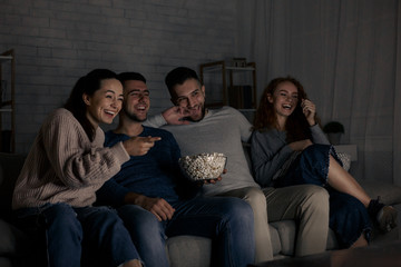 Happy friends watching comedy film at home