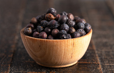 Bowl Full of Dried Juniper Berries on a Wooden Table