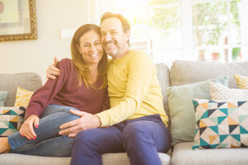 Middle age romantic couple sitting on the sofa at home