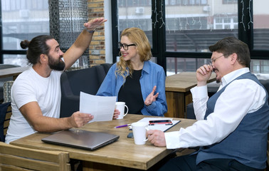 Group of people sitting at the table in the office, have fun discussing the project implementation plan. Teamwork.