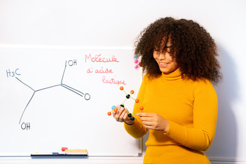 Student girl hold acid molecule drawn on the desk