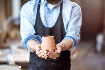 Potter with ceramic jug at the pottery shop