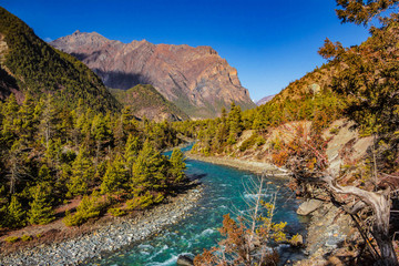 Fototapeta na wymiar View of the blue mountain river Nepal flowing into the gorge