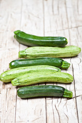 Fresh green zucchini on wooden rustic table.