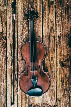 The abstract art desig nbackground of  wooden violin and bow put on wooden timber board,blurry light around