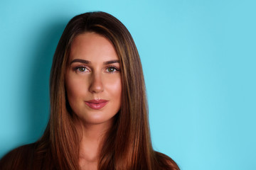 Fototapeta premium Serious, confident young girl looking straight, isolated on blue background. Psychology, body language concept