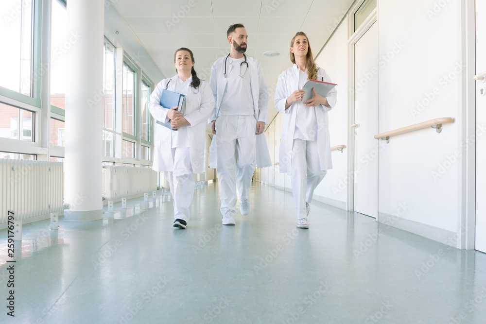 Wall mural doctors, two women and a man, in hospital - Wall murals