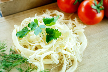 white cream cheese with herbs and spices on a wooden Board decorated with fresh dill, slices of bread and ripe tomatoes