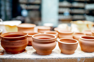 Close-up of clay pitchers before baking on the shelves at the pottery